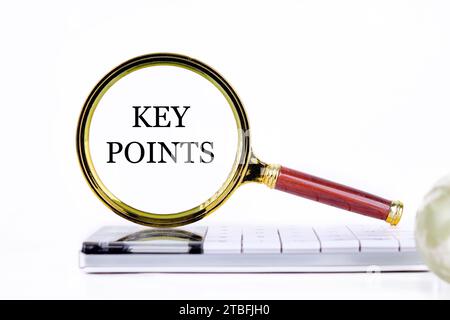 KEY POINTS lettering through a magnifying glass on a calculator and part of a magic ball in the foreground without focus Stock Photo