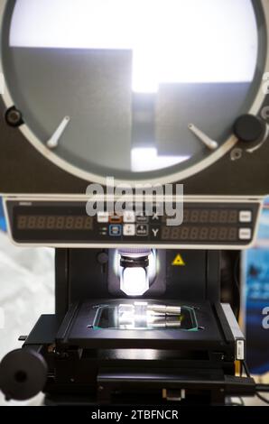 Profile projector dimension measurement machine measuring workpiece dimension in second. Industrial manufacturing Stock Photo