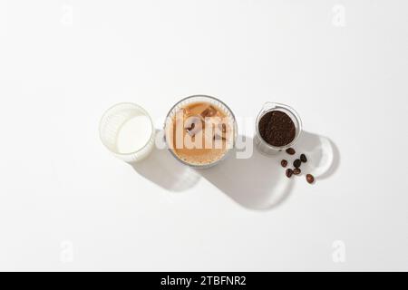 A cup of milk, a cup of milk coffee and a beaker containing coffee powder on white background. Caffeine in coffee brings many health benefits to the b Stock Photo