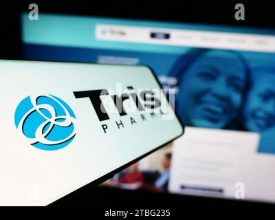 Smartphone with logo of American biopharmaceutical company Tris Pharma Inc. in front of business website. Focus on left of phone display. Stock Photo