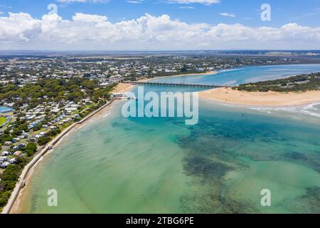 Aerial view of a wide river flowing under a bridge joining two coastal towns at Barwon Heads in Victoria, Australia Stock Photo