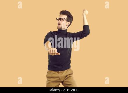 Handsome young man dancing Gangnam style over studio background Stock Photo