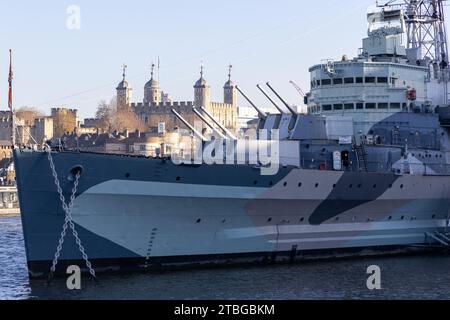 HMS Belfast, an ex-Royal Navy, now museum ship is seen docked on the River Thames, London, UK with the Tower of London in the background Stock Photo