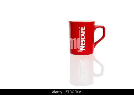 Zaporizhzhia, Ukraine - November 12, 2023: Red branded cup with Nescafe logo isolated on white background with reflection Stock Photo