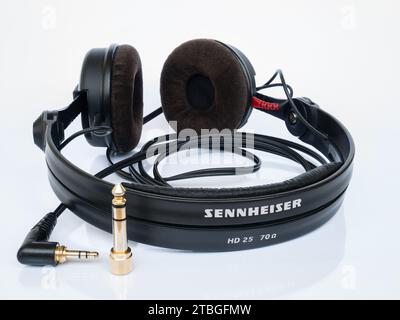 Sennheiser  closed-back HD 25 headphones with velour ear pads and 1/4' jack adapter on a white background with reflection Stock Photo