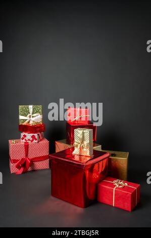 A lot of wrapped Christmas gift boxes. Red, white and golden color on black background Stock Photo