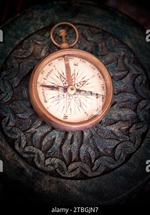 An antique compass on a wooden table Stock Photo