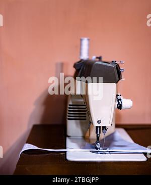 An old sewing machine situated on a wooden table in a home interior Stock Photo