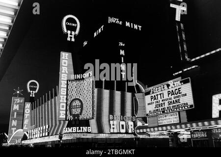 Nachtansicht der Fremont Street in Las Vegas mit dem ehemaligen The Mint Hotel, heute Teil von Binion's Horseshoe aka Binion's Gambling Hall and Hotel, und dem Fremont Hotel and Casino mit Patti Page im Bühnenprogramm, 1968. Night view of Fremont Street in Las Vegas with the former The Mint Hotel, now part of Binion's Horseshoe aka Binion's Gambling Hall and Hotel, and the Fremont Hotel and Casino with Patti Page on stage, 1968. Stock Photo