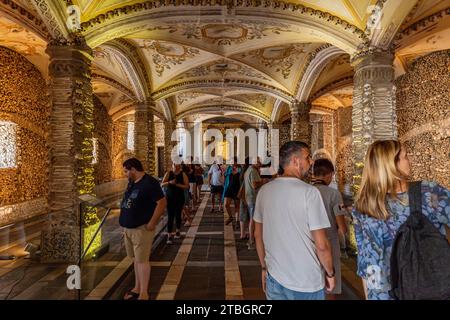 Tourists visiting the Chapel of Bones in wonder and amazement. Built with bones and human skulls in the 17th century at the initiative of three Franci Stock Photo