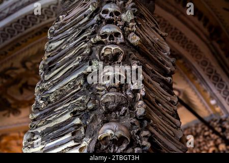 Column of human skulls with bones on the sides creating a macabre design of The Chapel of Bones located in the city of Évora in Portugal.17th century Stock Photo