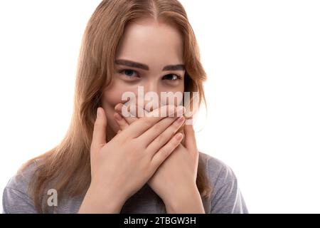 Modest teenage girl with blond hair and braces on a white background Stock Photo