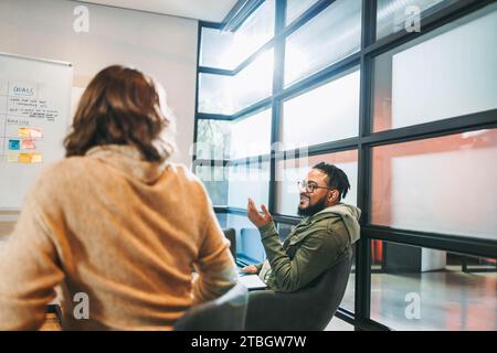 Professionals brainstorm and collaborate in a vibrant office setting. Diverse team members, male and female, discuss ideas, ensuring project success. Stock Photo