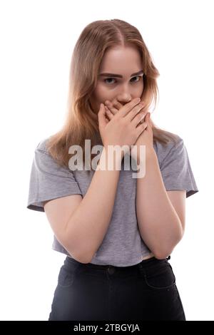 Fearful teenage girl with blond hair in a T-shirt on a white background Stock Photo