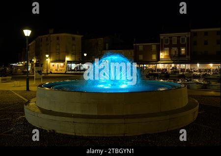 Cres, Croatia - April 8, 2023: Detail of a fountain on the main square near the harbor in Cres with colored lights Stock Photo