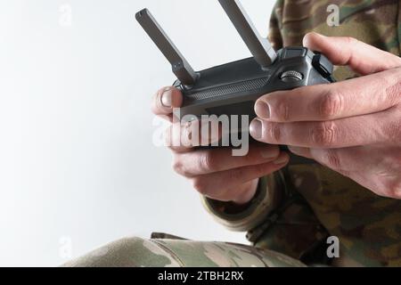 Soldier in military uniform holding drone remote control close-up. Concept of drones in modern war. Stock Photo