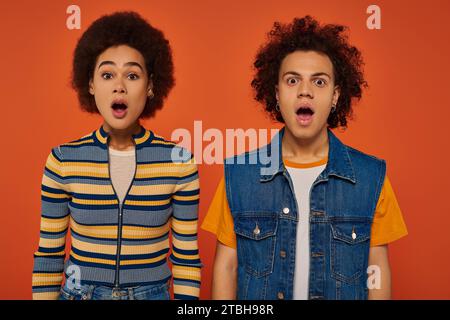 surprised young african american brother and sister looking at camera with slightly open mouths Stock Photo