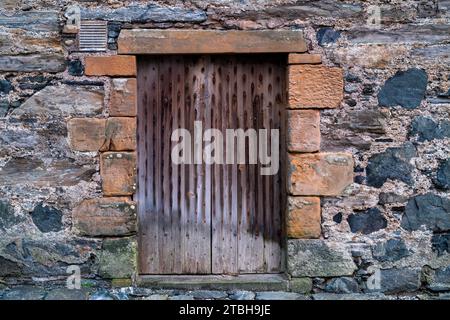 Portsoy historic building wall and wooden doors. Aberdeenshire, Scotland Stock Photo