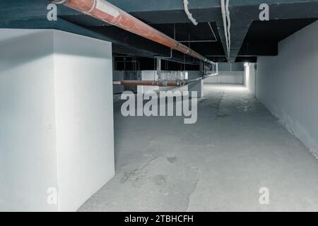 an long pipe in a technical room in the basement of a large building. Industrial, technology and energy saving concepts. Stock Photo