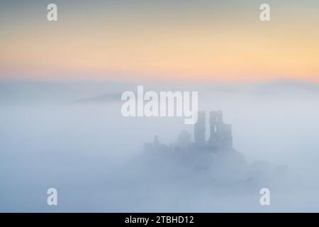 Corfe Castle emerging from mist on a frosty wintry morning, Dorset, England. Winter (February) 2023. Stock Photo