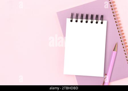 Workspace with clean notepad mockup and purple colored stationery on a pink background. Office supplies. Stock Photo