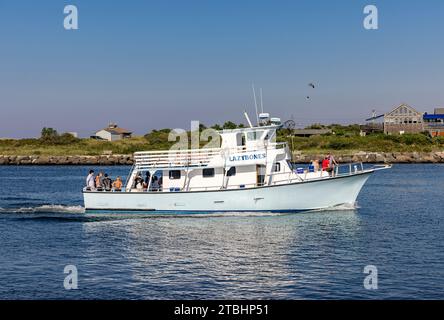 Chartered fishing vessel, Lazy Bones motoring into montauk Stock Photo