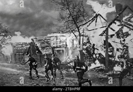 Soldiers of the Wermacht advancing past a blazing Russian village in September 1941 during the German invasion of Russia in the Second World War. Stock Photo