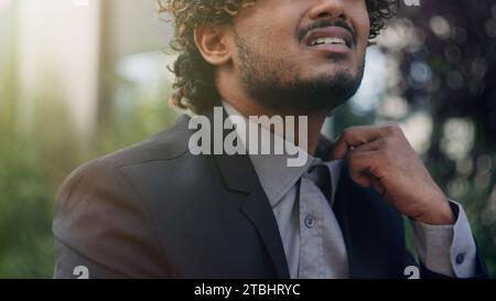 Tired exhausted unwell bad feeling Hispanic businessman suffering high temperature summer in urban city outdoors wearing uncomfortable collar tight Stock Photo