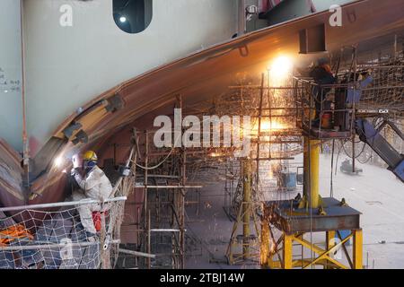 (231207) -- NANJING, Dec. 7, 2023 (Xinhua) -- Workers work at a shipyard of Jiangsu Yangzi Xinfu Shipbuilding Co., Ltd. in Taixing, east China's Jiangsu Province, Dec. 5, 2023. In the first 10 months of 2023, China has maintained its top position in the global shipbuilding market with strong growth in both output and new orders, industry data showed. The country's shipbuilding output climbed 12 percent year on year to 34.56 million deadweight tonnes (dwt) during the January-October period, accounting for 49.7 percent of the world's total, according to data from the China Association of the Stock Photo