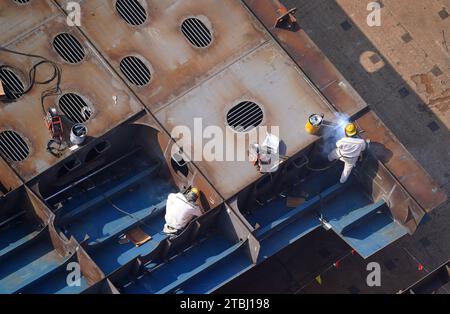 (231207) -- NANJING, Dec. 7, 2023 (Xinhua) -- Workers work on components of a container vessel at a shipyard of Jiangsu Yangzi Xinfu Shipbuilding Co., Ltd. in Taixing, east China's Jiangsu Province, Dec. 5, 2023. In the first 10 months of 2023, China has maintained its top position in the global shipbuilding market with strong growth in both output and new orders, industry data showed. The country's shipbuilding output climbed 12 percent year on year to 34.56 million deadweight tonnes (dwt) during the January-October period, accounting for 49.7 percent of the world's total, according to dat Stock Photo