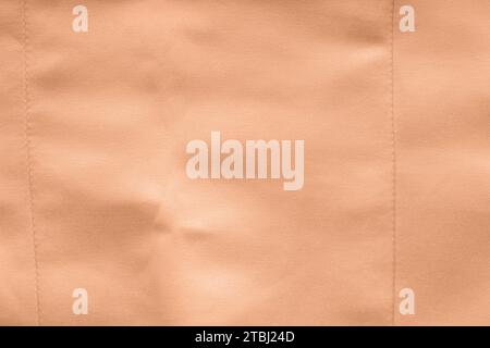 Peach fuzz satin fabric. Bridal wedding dress textile background. Stock Photo