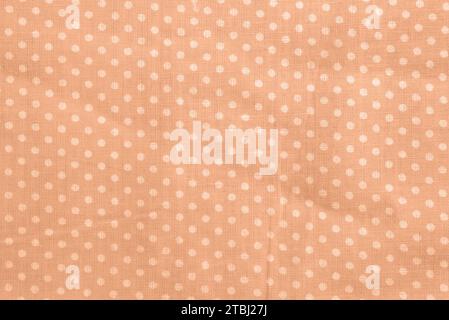 Peach fuzz polka dot cotton texture. Fabric textile background Stock Photo