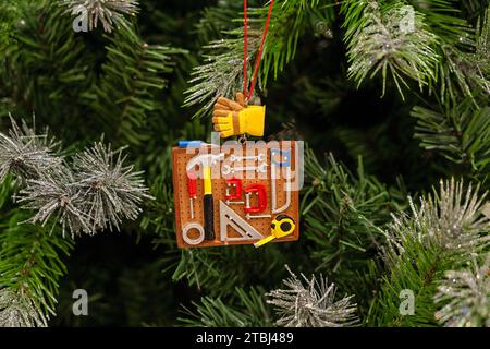 Christmas ornament with construction equipment tools. Hardware for repair work in construction industry: screwdriver, saw, drill, hammer, screw, clamp Stock Photo