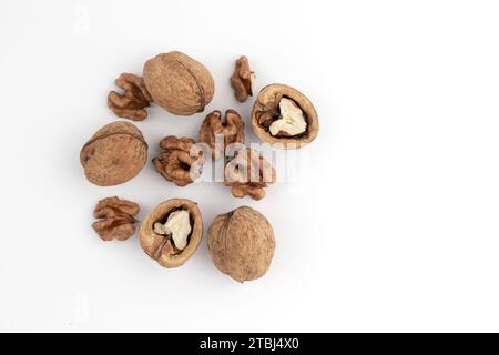 heap of walnuts isolated on white background, whole and cracked walnut, top view Stock Photo