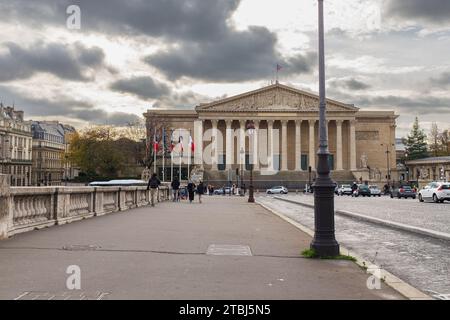 Paris, France, 2023. People and cars crossing the Pont de la Concorde towards the Palais Bourbon which houses the National Assembly Stock Photo