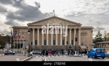 Paris, France, 2023. People walking across the Pont de la Concorde in front of the Palais Bourbon which houses the National Assembly Stock Photo