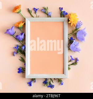 Text frame with flowers bells and calendula. Trendy color of year 2024 - Peach Fuzz. Trendy color palette sample. Stock Photo