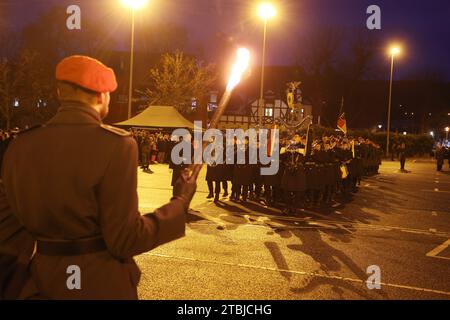 Gera, Germany. 07th Dec, 2023. A Bundeswehr soldier stands with a torch in his hand at the public swearing-in ceremony for around 100 recruits of the 5th company of the armored engineer battalion 701 in the Hofwiesen parking lot. Credit: Bodo Schackow/dpa/Alamy Live News Stock Photo