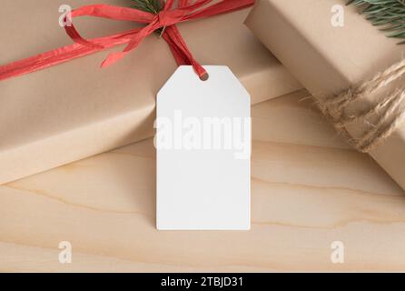 White blank tag mockup isolated on a kraft christmas gift. Stock Photo