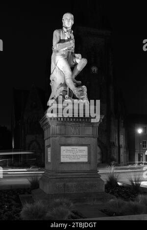 The poet Robert Burns statue in Dumfries town centre, Greyfriars Church behind at night Scotland UK Stock Photo