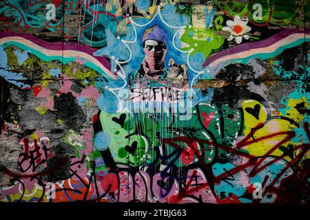 A graffiti-covered brick wall featuring a variety of spray-painted artwork Stock Photo