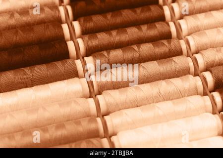 Beige threads lying in a box. Concept of hobbies and handmade. Demonstrating peach color of 2024 year. Stock Photo