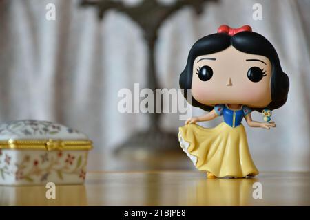 Funko Pop action figure of   Disney princess Snow White. Vintage interior, old candlestick, white flower printed jewelry box. Stock Photo