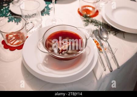 Christmas beetroot soup, borscht with small dumplings with mushroom filling in a ceramic bowl on a table. Traditional Christmas eve dish in Poland.  Stock Photo