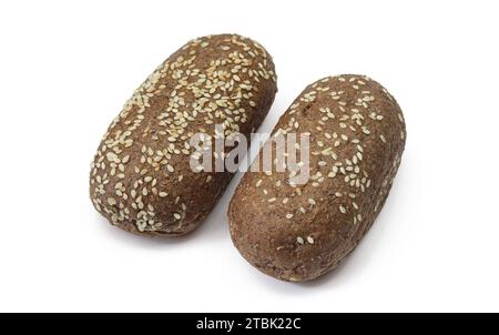 Two integral dark flour bun pastries sprinkled with sesame seeds isolated on white background Stock Photo