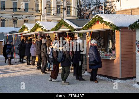 People and market kiosks at Tuomaan markkinat or Helsinki Christmas Market on Senate Square in Helsinki, Finland Stock Photo