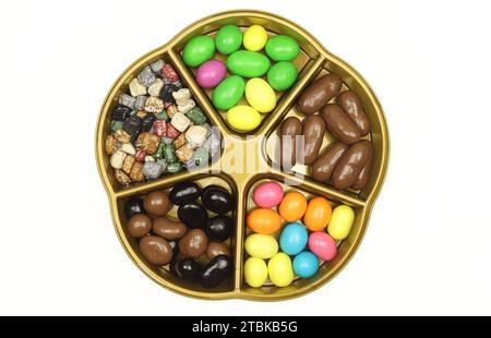 Plastic five section divider plate filled with colorful chocolate snacks isolated on white background Stock Photo