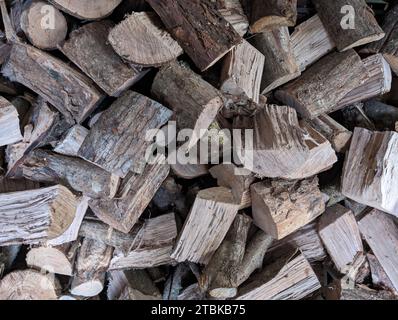 Various pieces of chopped wood stacked on top of each other to form a pile, ideal for firewood or other woodworking projects Stock Photo