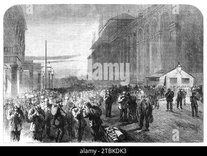 Progress of the Great International Exhibition building: the workmen leaving the grounds, [South Kensington, London], 1861. Our engraving represents a picturesque scene enough, which takes place in the closing gloom every evening - the workmen employed upon the building (in round numbers, some thousand) leaving the building and proceeding to their homes. Such a mass of human industry and intelligence was perhaps never before seen issuing from one field of labour of similar dimensions. The men employed upon this great work, we understand, are all picked men of their several classes; and, from a Stock Photo