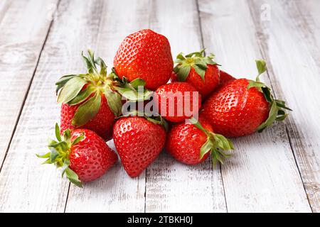 Berries of large ripe fresh organic strawberries on a wooden background close-up. Stock Photo